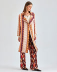 Playful and sophisticated coral jacket with distinctive fringed patterns