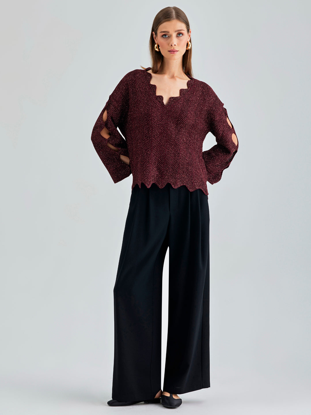 Ernesta Sweater Bordeaux in rich red with avant-garde asymmetrical cut-outs climbing the sleeves