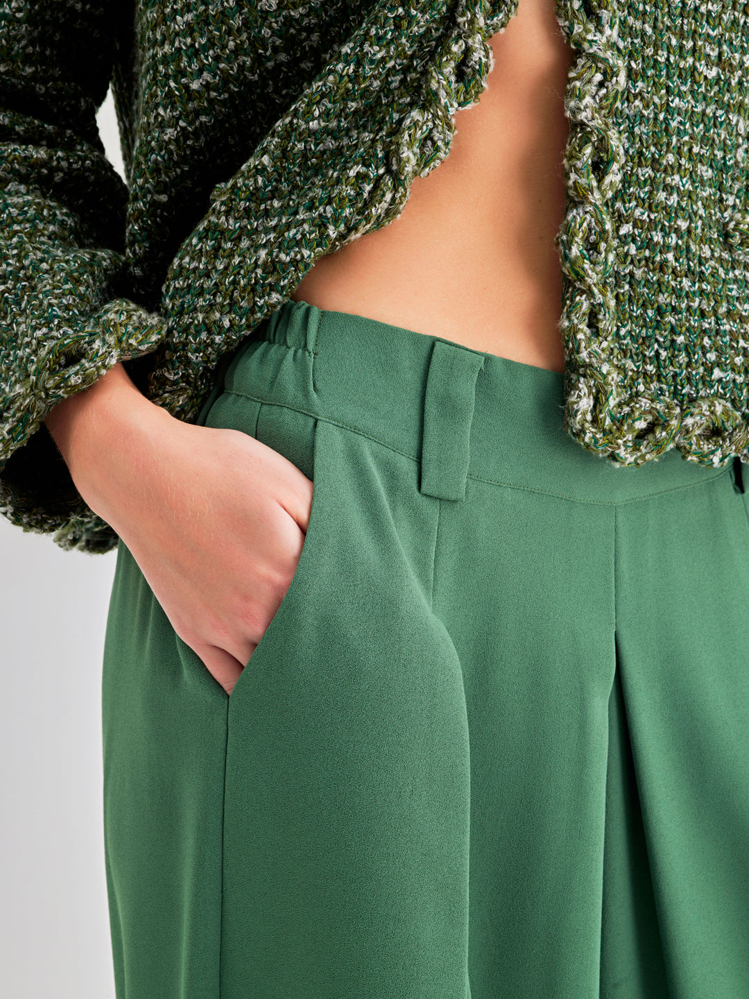 Elegant green high-rise trousers with pleated detailing and wide-leg design