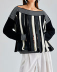 Jadira Sweater with black, grey, and white vertical stripes and unique gaps for a modern twist