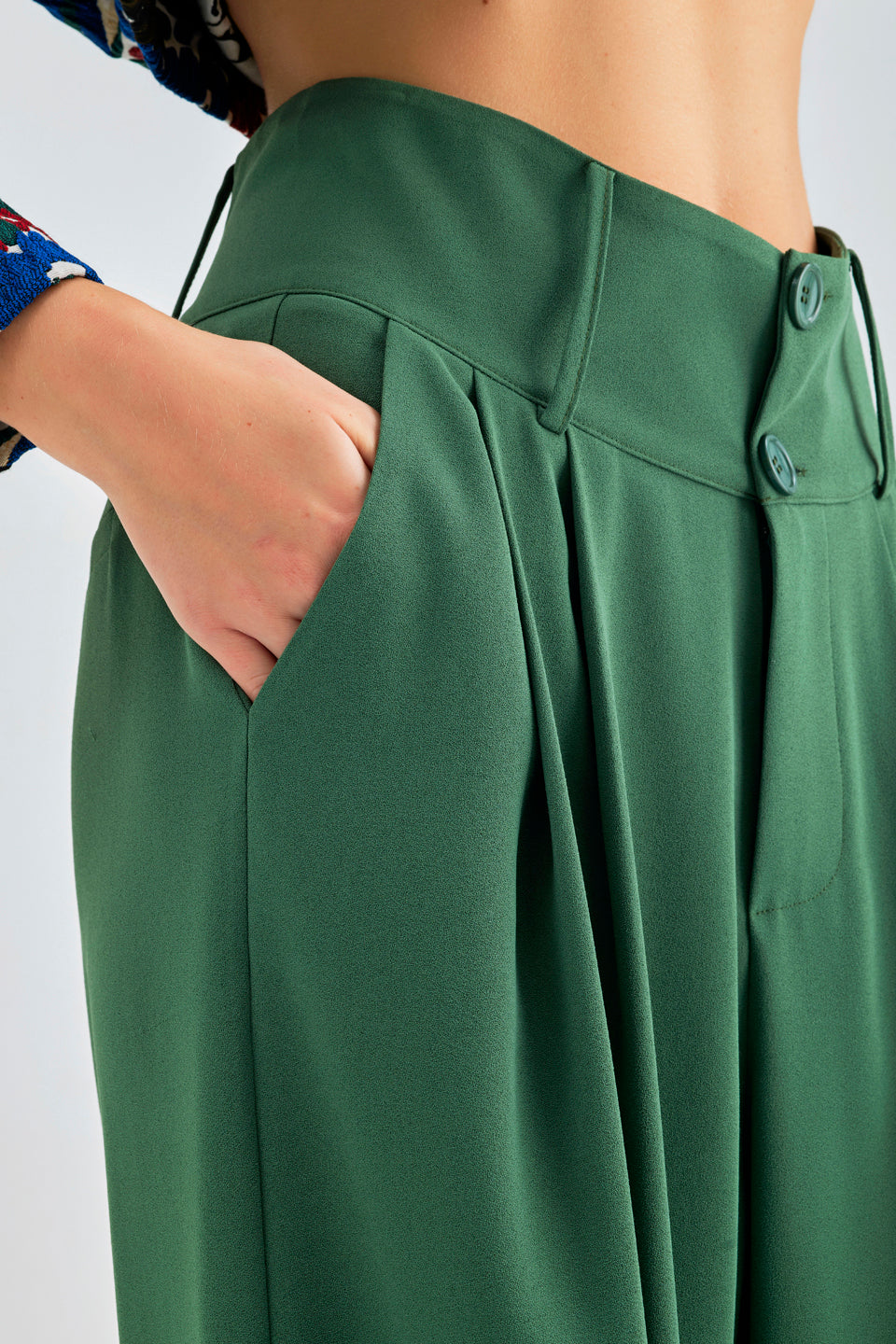 Elegant green trousers featuring button-fastened waistband and flowing wide-leg design