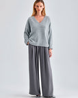 Classic Kate Sweater in grey featuring ribbed cuffs and a V-neck design, ideal for casual and dressy wear