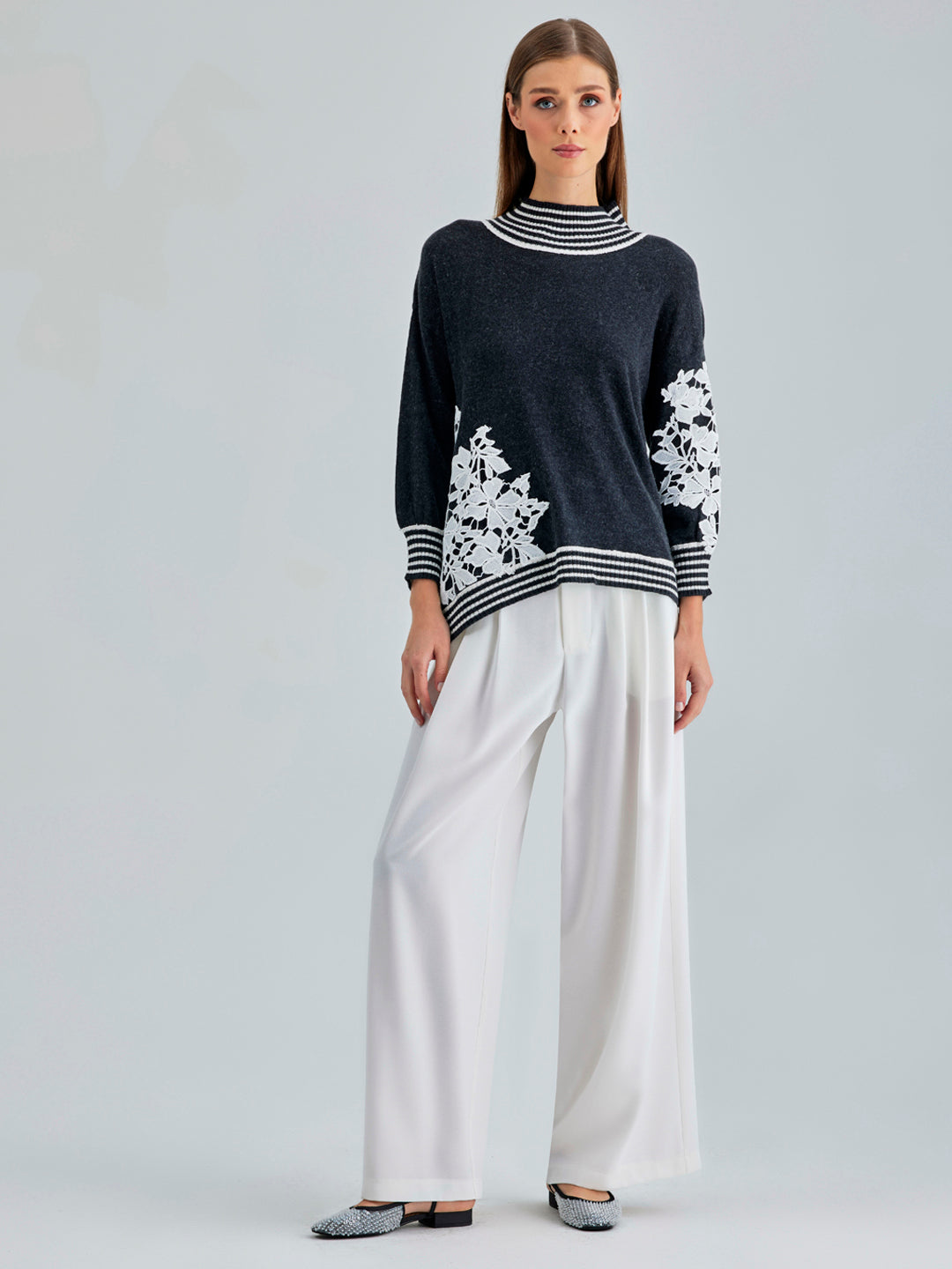 Elegant Leti Sweater featuring white floral accents along the sleeves and edges for a refined look