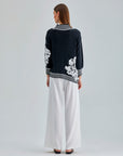 Timeless Leti Sweater featuring soft fabric and intricate white floral details for a modern, feminine appeal