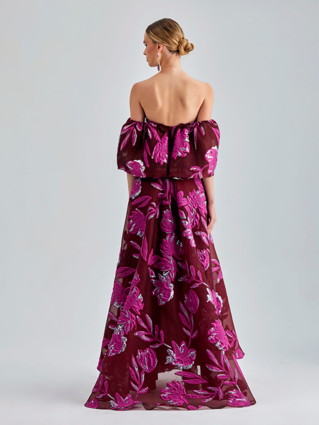 Red Zelene Gown featuring large floral patterns, low-cut shoulders, and a flowing, elegant design