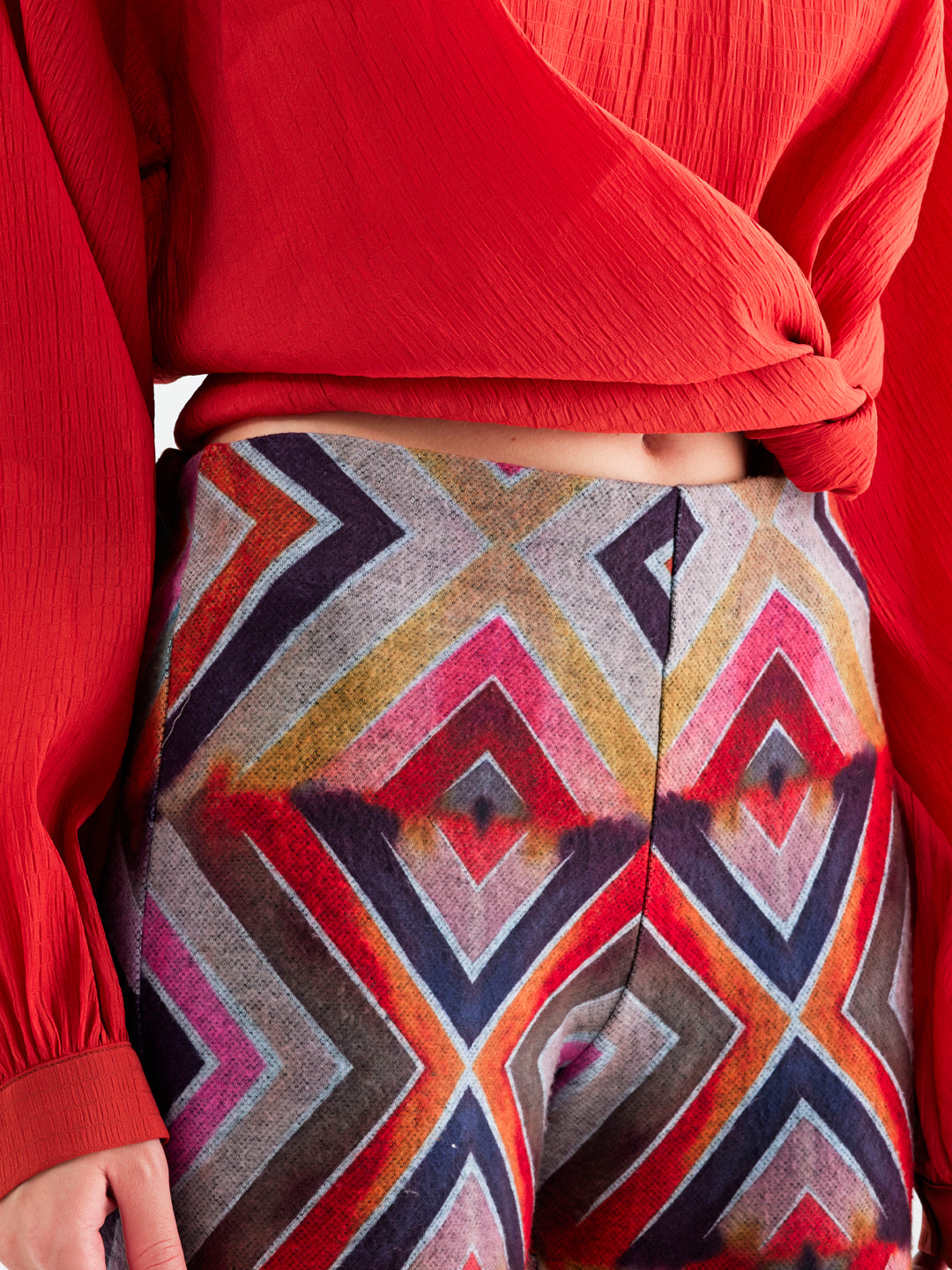 Siara Pants featuring vibrant geometric patterns in reds, pinks, yellows, and oranges